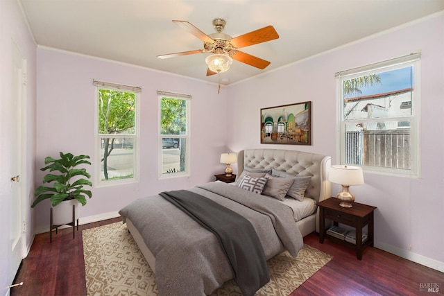 bedroom with baseboards, crown molding, ceiling fan, and wood finished floors