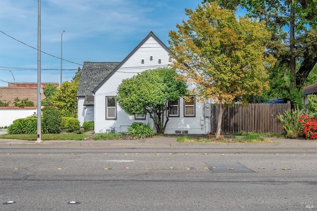 view of front facade featuring fence and stucco siding