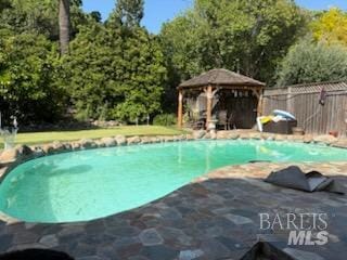 view of pool with a gazebo, a patio area, fence, and a fenced in pool