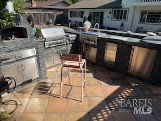 view of patio with an outdoor kitchen and a grill