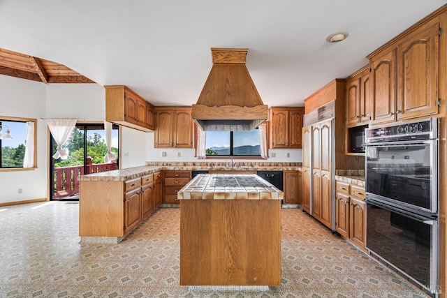 kitchen featuring a center island, custom exhaust hood, tile counters, a peninsula, and black appliances