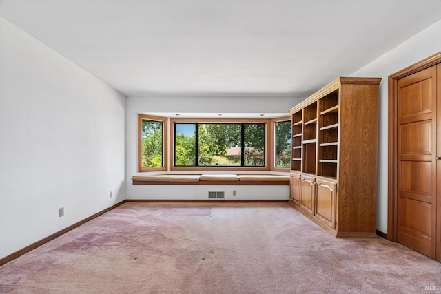 unfurnished room with light colored carpet, baseboards, and visible vents