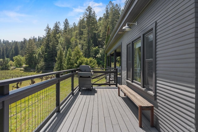 deck featuring area for grilling and a wooded view