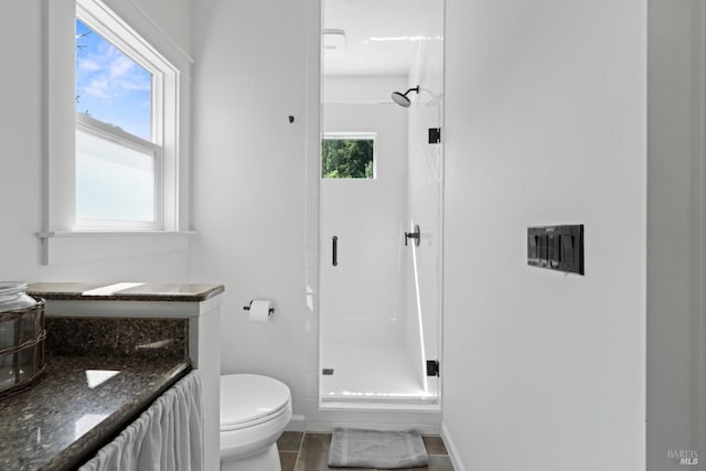 bathroom with baseboards, a healthy amount of sunlight, and a shower stall