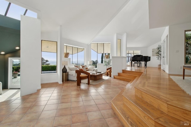 living area with baseboards, a high ceiling, and a wealth of natural light