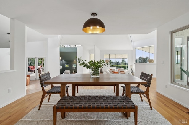 dining space with baseboards, plenty of natural light, and light wood-style flooring