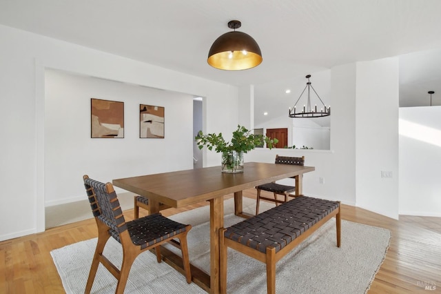 dining room featuring baseboards, an inviting chandelier, and light wood-style flooring