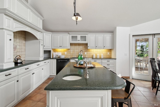 kitchen with light tile patterned floors, tasteful backsplash, a sink, and dishwasher