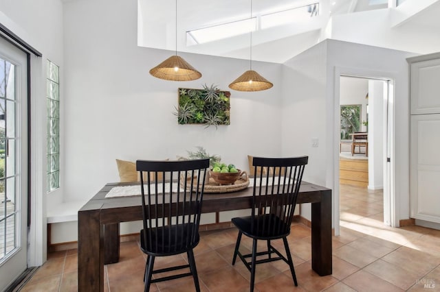 dining area featuring a towering ceiling and tile patterned floors