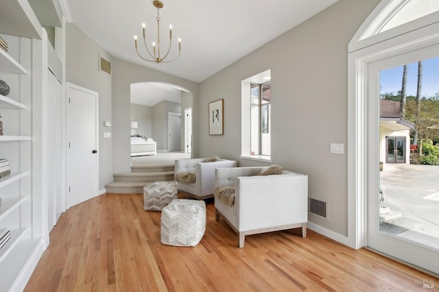 sitting room with arched walkways, a healthy amount of sunlight, and light wood finished floors