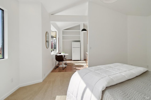 bedroom featuring baseboards, freestanding refrigerator, and carpet