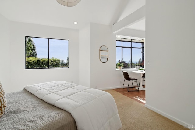 carpeted bedroom with baseboards, multiple windows, recessed lighting, and lofted ceiling