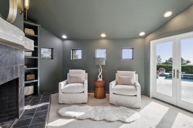 sitting room featuring a premium fireplace, french doors, recessed lighting, and lofted ceiling