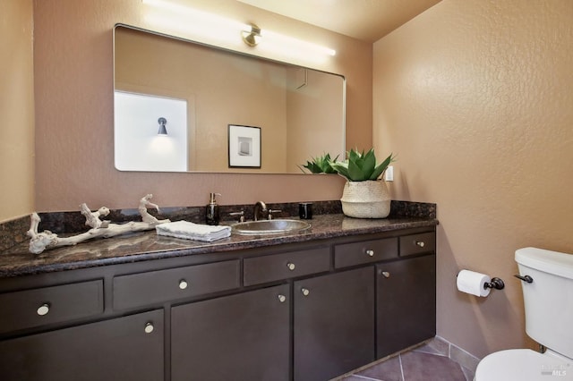 bathroom featuring vanity, tile patterned flooring, and toilet