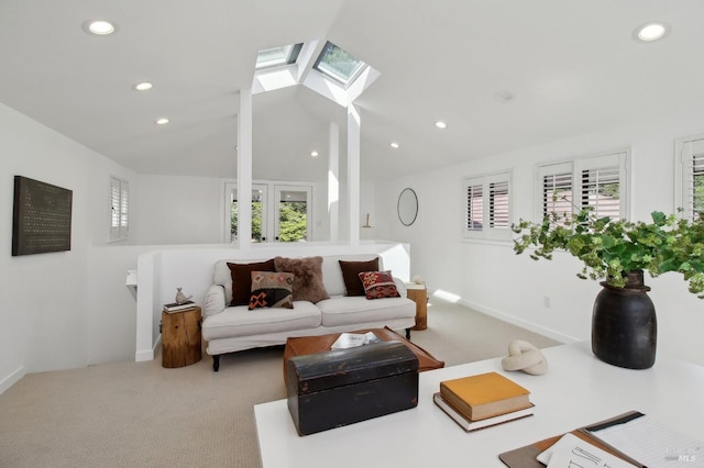 carpeted living area featuring vaulted ceiling with skylight, baseboards, and recessed lighting