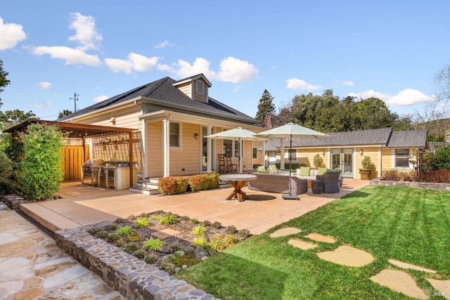 rear view of house with a yard, fence, french doors, and a patio area