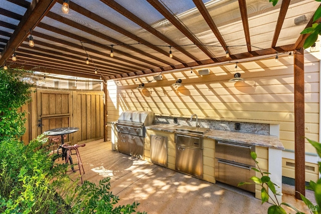 view of patio with a ceiling fan, fence, a sink, and area for grilling