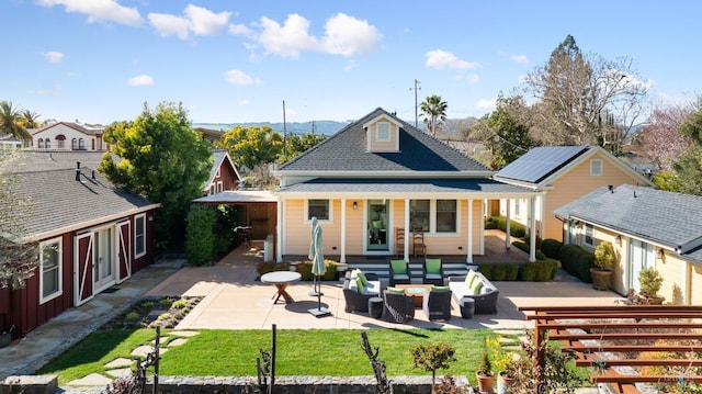 back of house with a patio, an outdoor living space, and roof with shingles