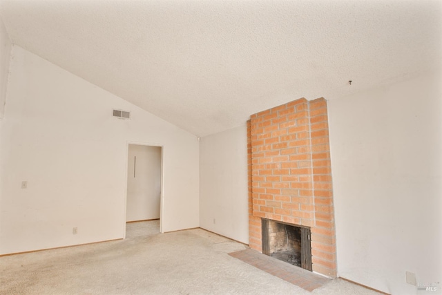 unfurnished living room with a fireplace, light carpet, lofted ceiling, and a textured ceiling