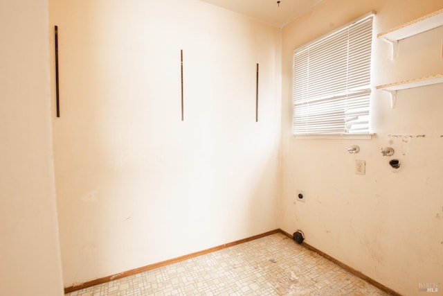 clothes washing area featuring hookup for an electric dryer, hookup for a gas dryer, light floors, and baseboards