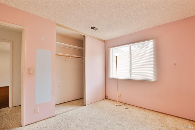 unfurnished bedroom featuring carpet, a closet, and a textured ceiling