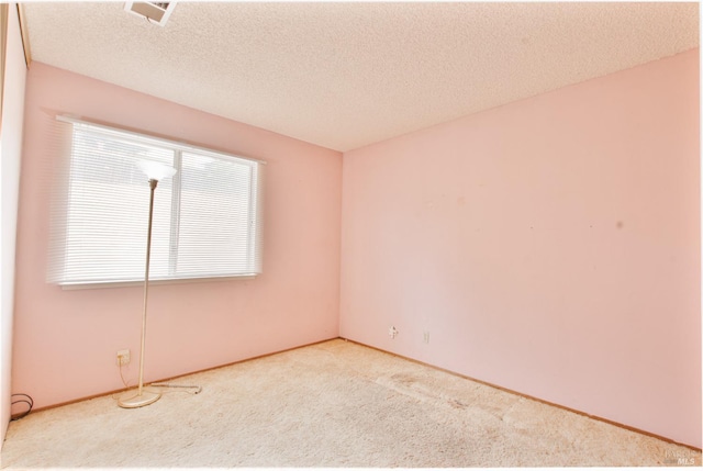 carpeted empty room featuring baseboards and a textured ceiling