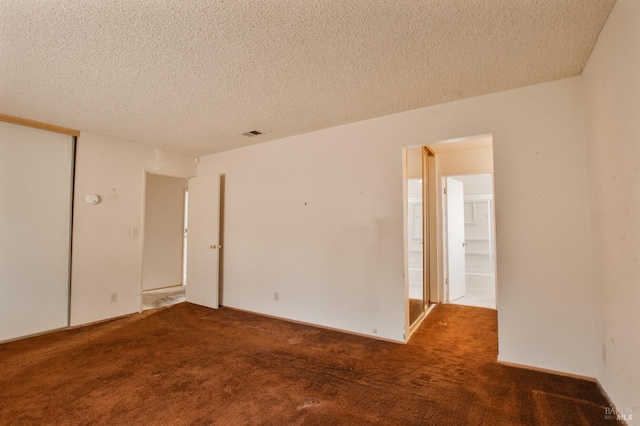 spare room featuring carpet floors and a textured ceiling