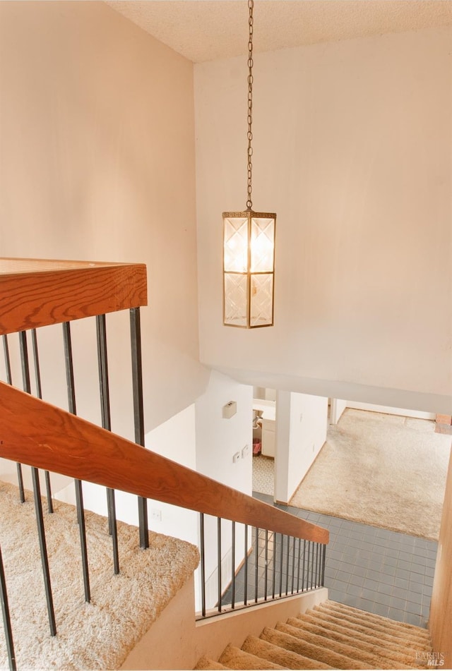 stairs with carpet flooring and a textured ceiling