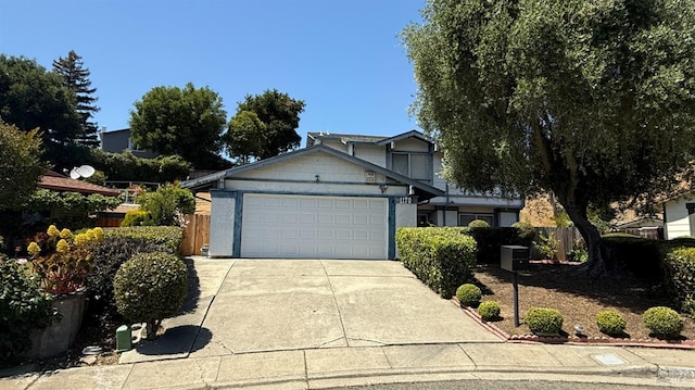 view of front of house with an attached garage, concrete driveway, and fence