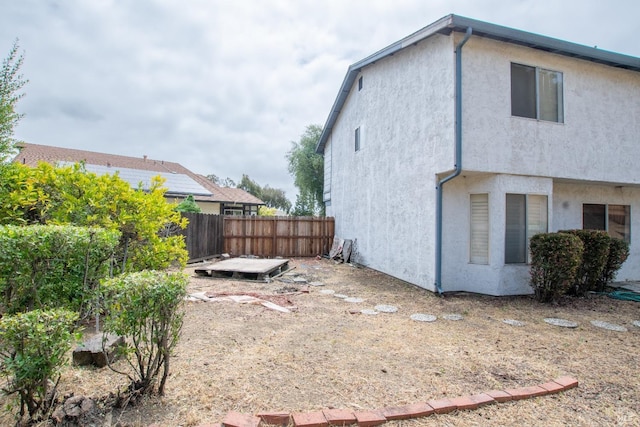 view of side of property featuring fence and stucco siding