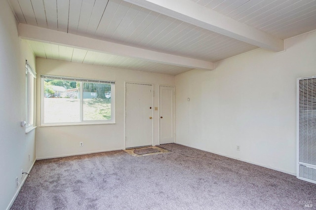 spare room featuring baseboards, a heating unit, carpet, and beamed ceiling
