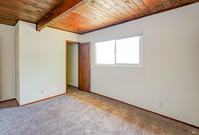 unfurnished room with baseboards, wood ceiling, beam ceiling, and light carpet
