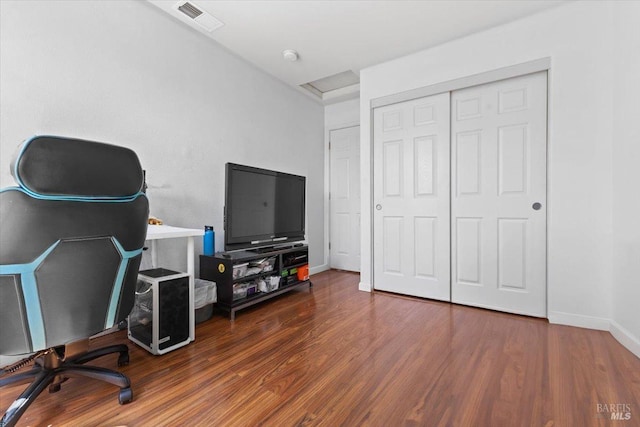 office area featuring baseboards, visible vents, and wood finished floors