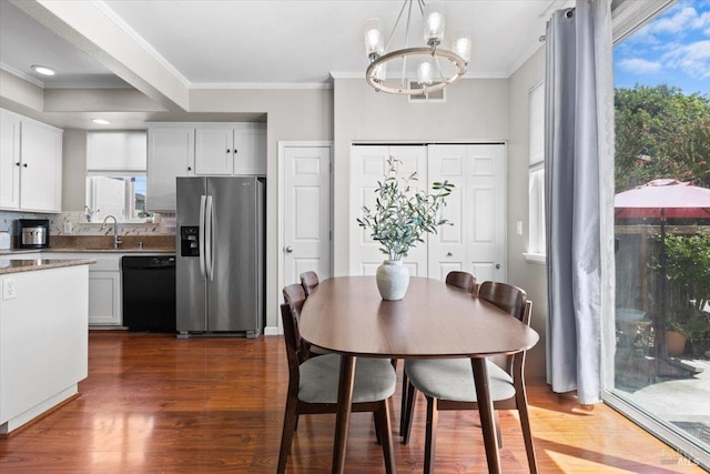 dining area featuring crown molding, recessed lighting, an inviting chandelier, and dark wood finished floors