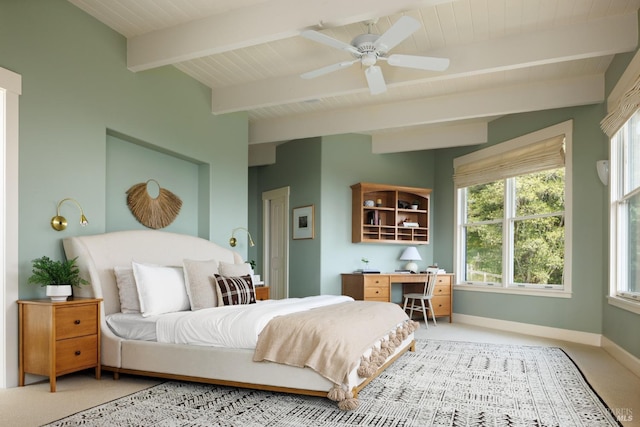 bedroom with baseboards, ceiling fan, beamed ceiling, and light carpet