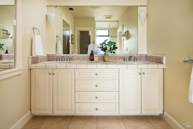 full bathroom featuring a sink, baseboards, and double vanity