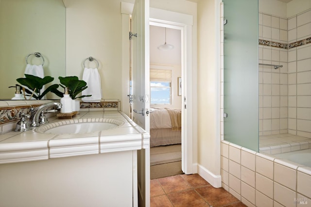 ensuite bathroom featuring vanity, connected bathroom, tile patterned floors, and a tile shower