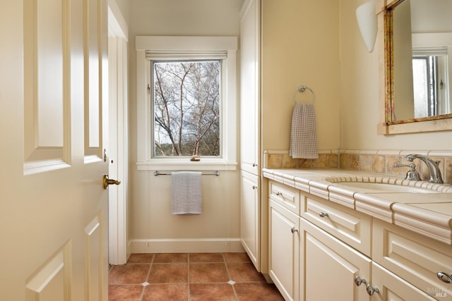 bathroom with baseboards, plenty of natural light, tile patterned flooring, and vanity