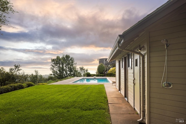 outdoor pool featuring a lawn