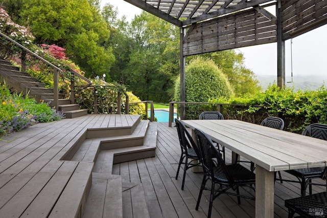 wooden terrace with stairway, a pergola, and outdoor dining space
