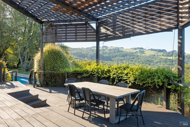 deck with a pergola, a mountain view, outdoor dining area, and an outdoor pool