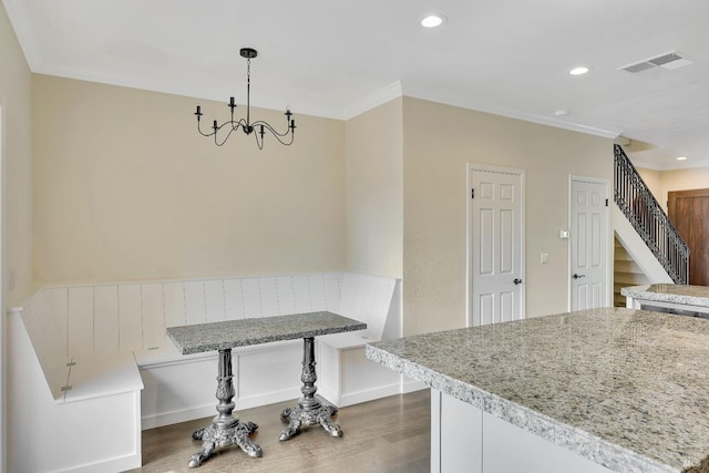 unfurnished dining area with an inviting chandelier, visible vents, wood finished floors, breakfast area, and stairway
