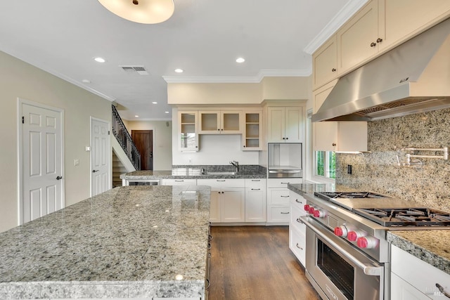 kitchen featuring stainless steel stove, recessed lighting, under cabinet range hood, visible vents, and ornamental molding
