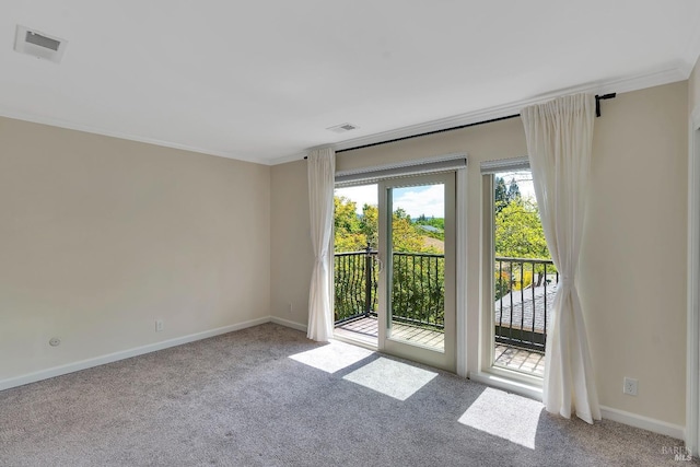 carpeted empty room with baseboards, ornamental molding, and visible vents