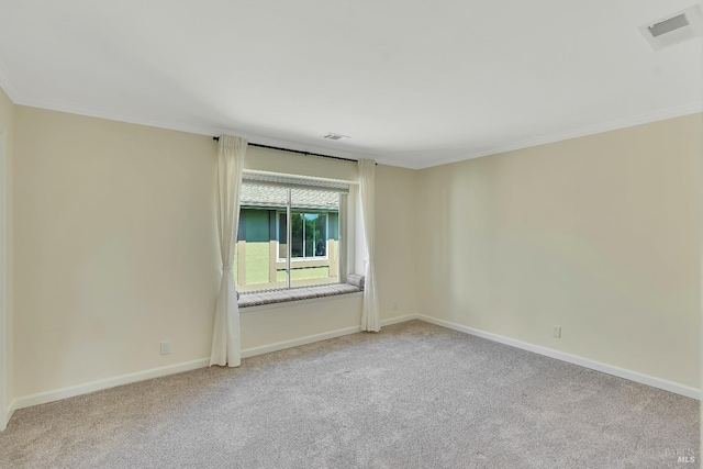 carpeted spare room with crown molding, baseboards, and visible vents