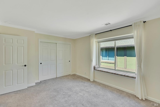unfurnished bedroom featuring baseboards, carpet, and visible vents