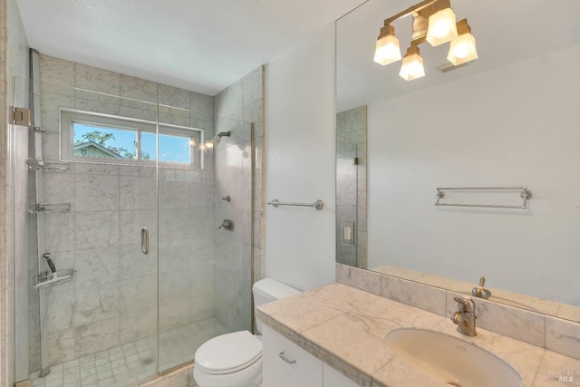 full bath with vanity, a shower stall, and toilet