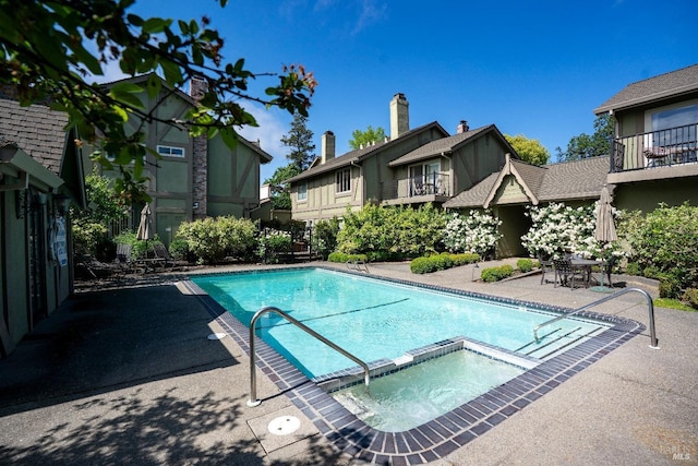 view of swimming pool featuring a patio and a pool with connected hot tub