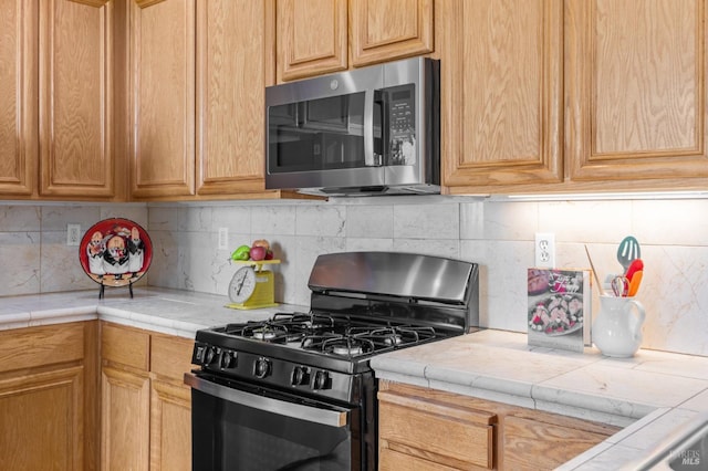 943 Bridgeport Way, Rio Vista, CA 94571 - kitchen with tile countertops, decorative backsplash, stainless steel microwave, and black gas range oven