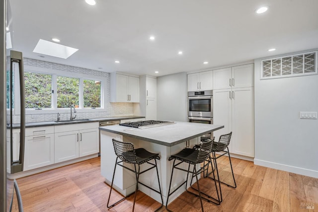 269 Corte Madera Ave, Mill Valley, CA 94941 - kitchen with a sink, a kitchen bar, a center island, a skylight, and white cabinets